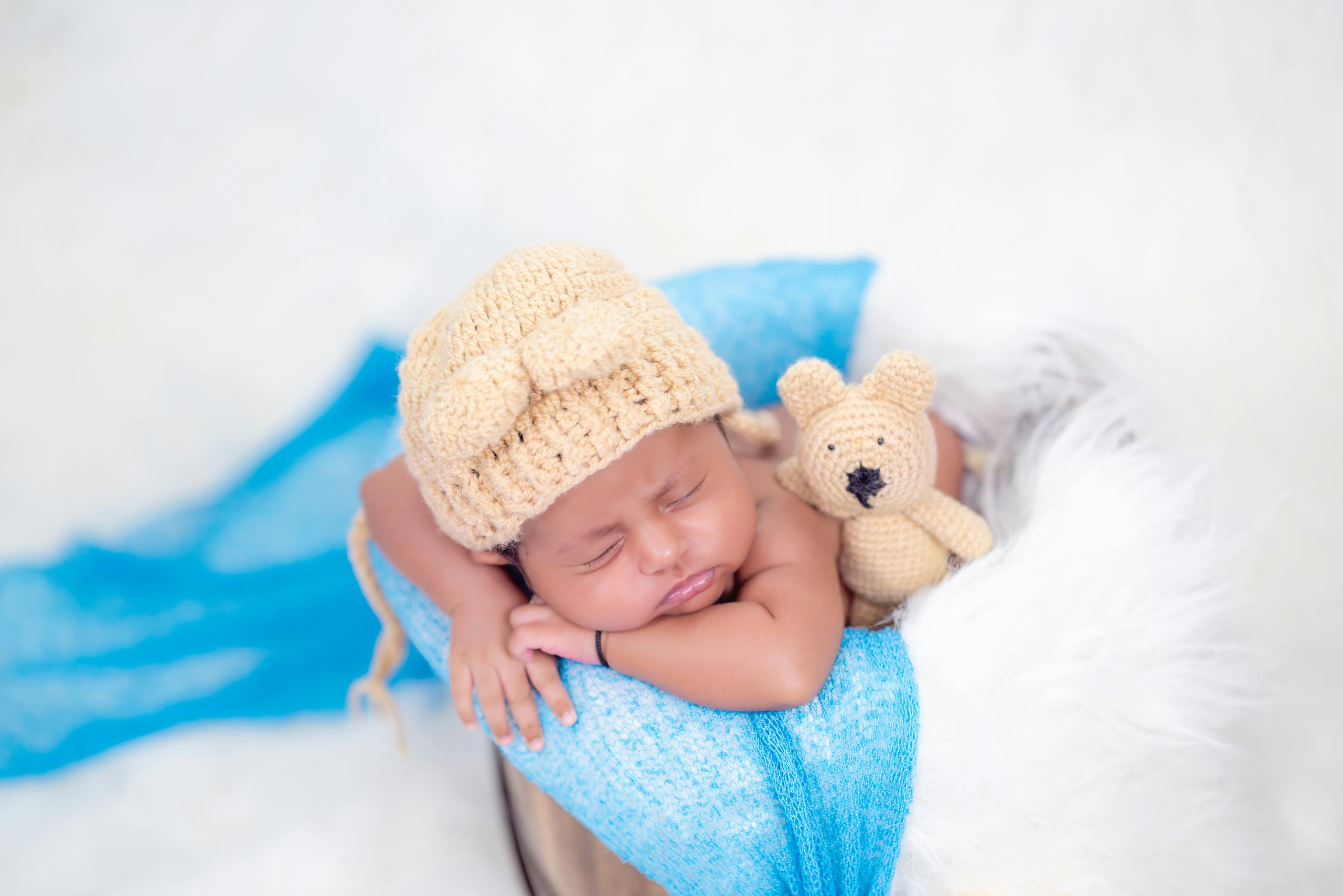 A newborn baby in a blue hat and blue sweater